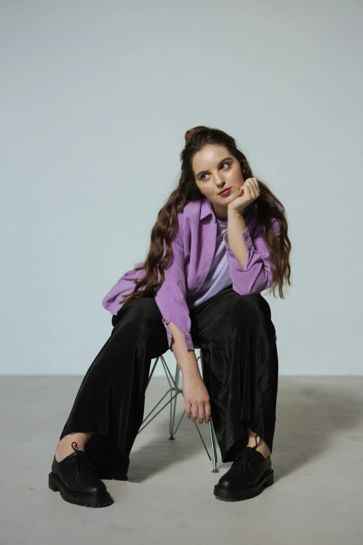 a girl sits in a chair, posing for the camera