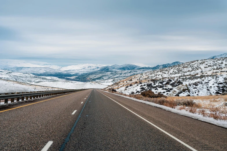 a snow covered mountain road on a cloudy day