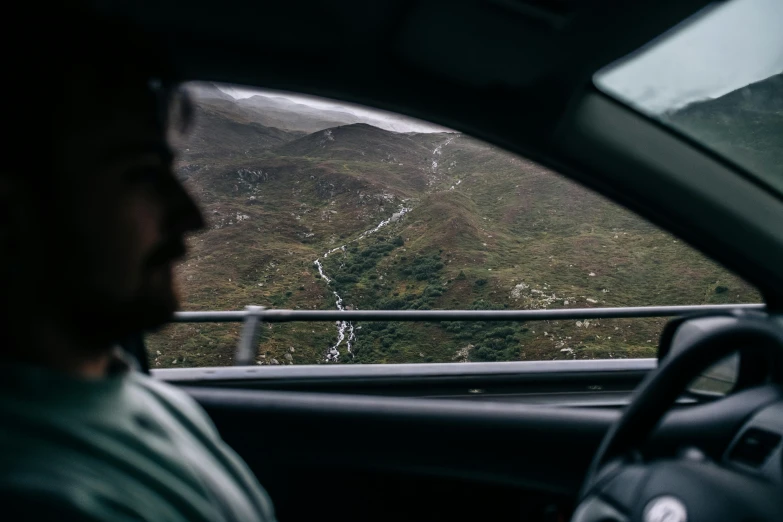 a car driving down a road with a mountain in the back