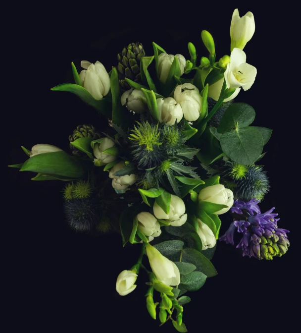 white and green flowers in a vase with leaves