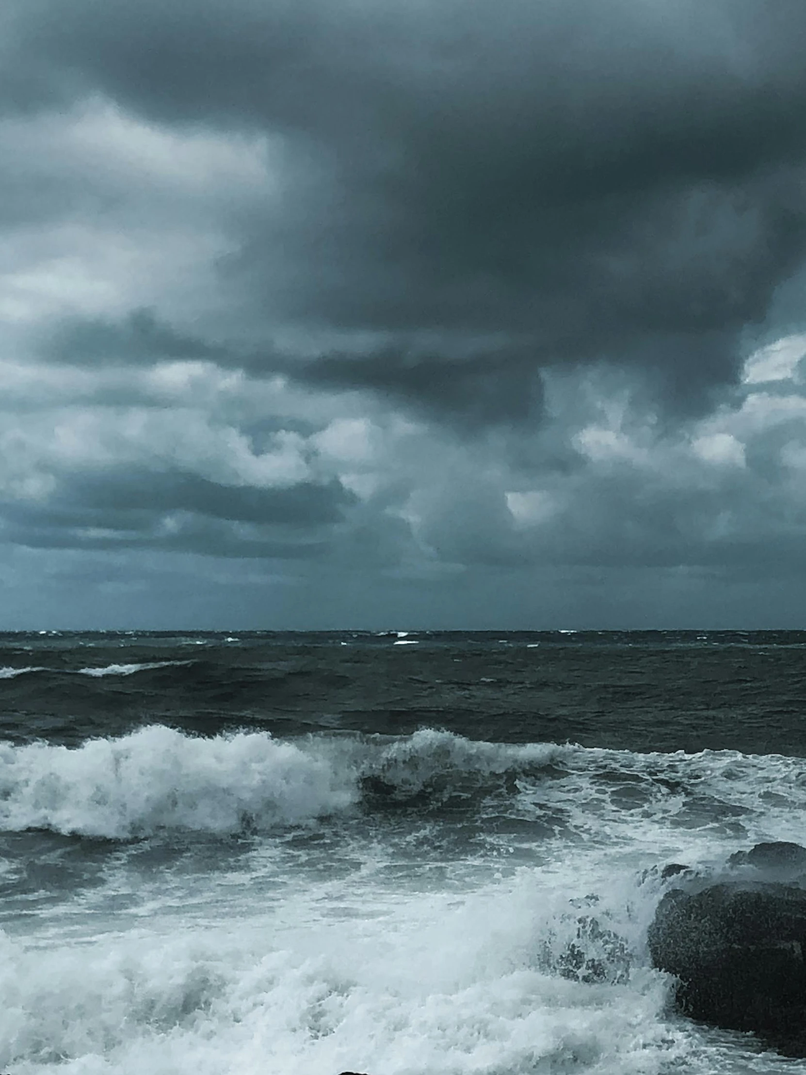 the water and stormy skies are in dark colors