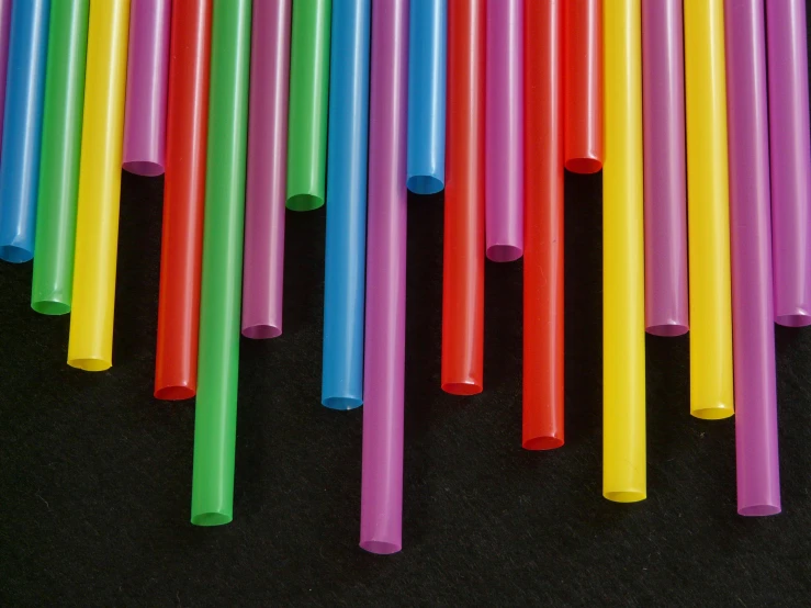 many different colored plastic straws and one of them is not