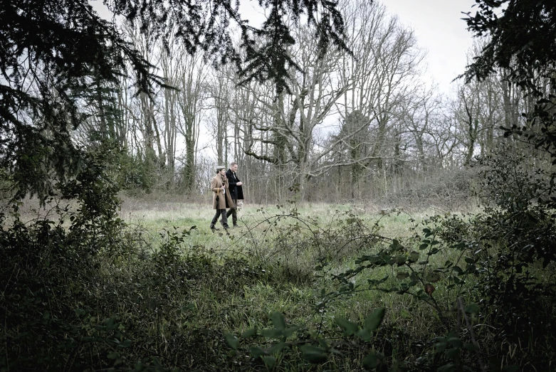 an engaged couple walk in the woods on a foggy day