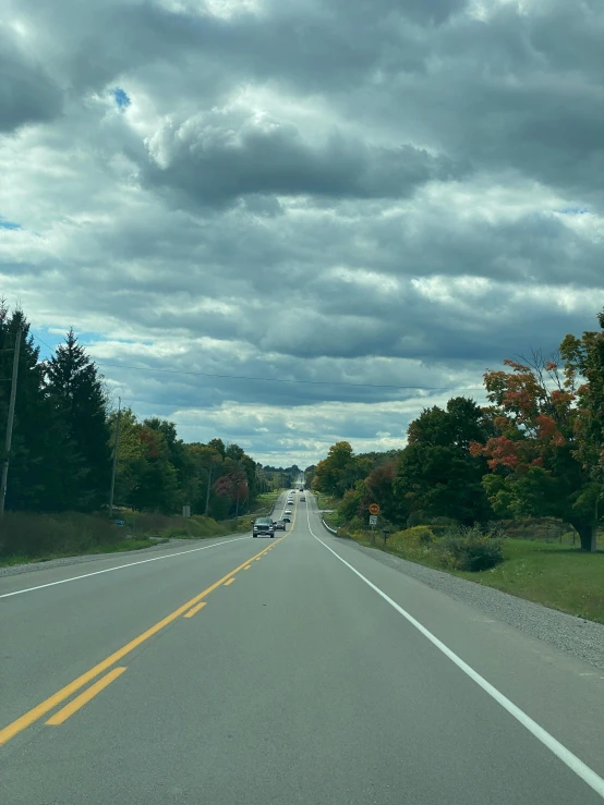 two cars sitting at the side of a road in a rural area