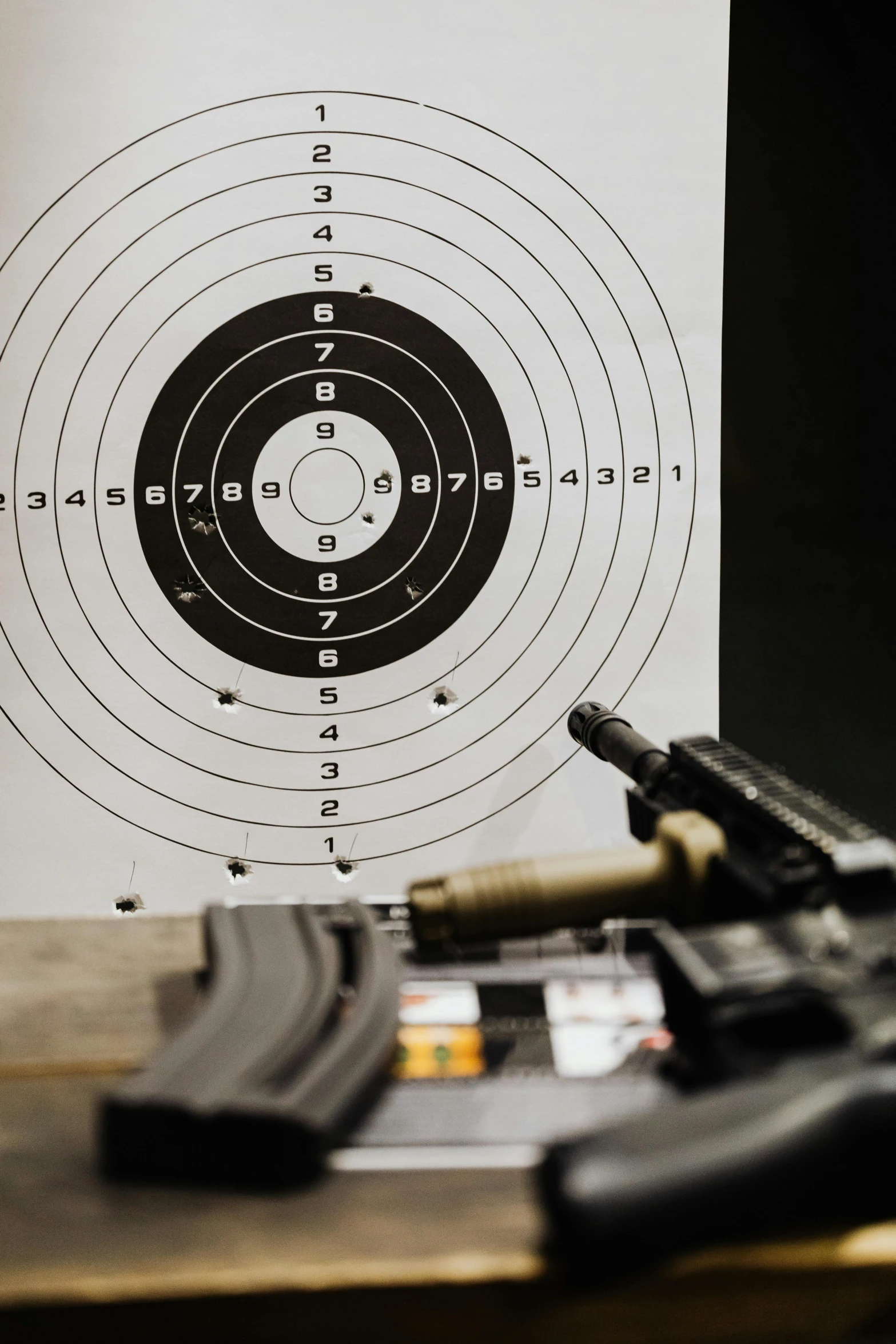 a handgun lies on the table and a target is in front of it