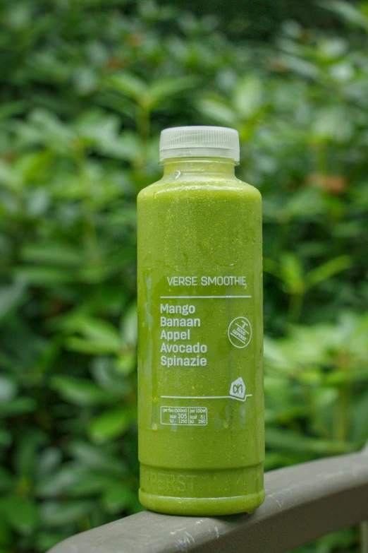 a close up of a bottle of green beverage