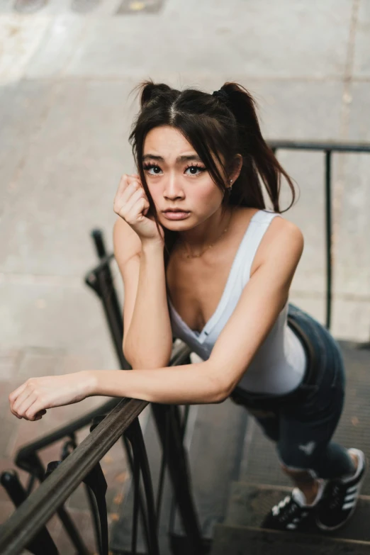 a beautiful young woman leaning on the railing of a balcony