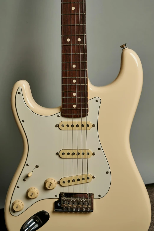 a white guitar has brown spots on it
