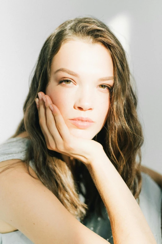 a woman is posing with her hands behind her head