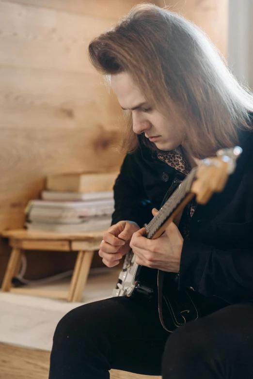 a man with long hair playing on an electric guitar