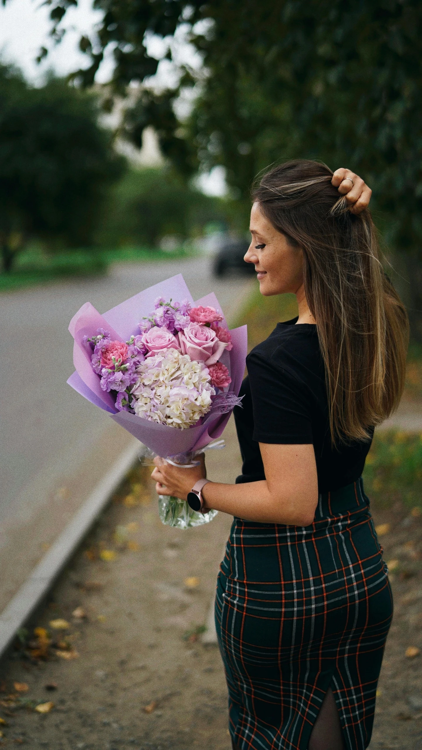 a girl holds a bouquet of flowers and looks off to the side