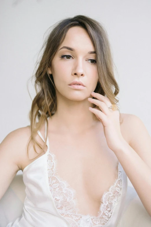 a woman posing in white wearing a white satin robe