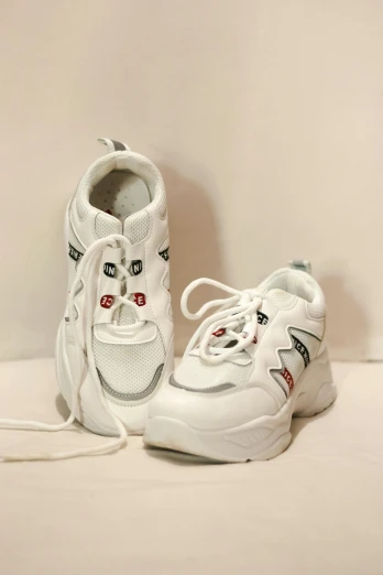 pair of sneakers with laces against plain background