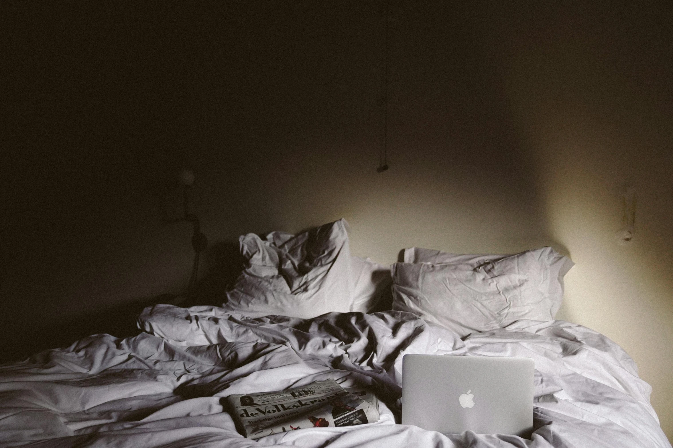 an apple laptop computer sitting on a bed