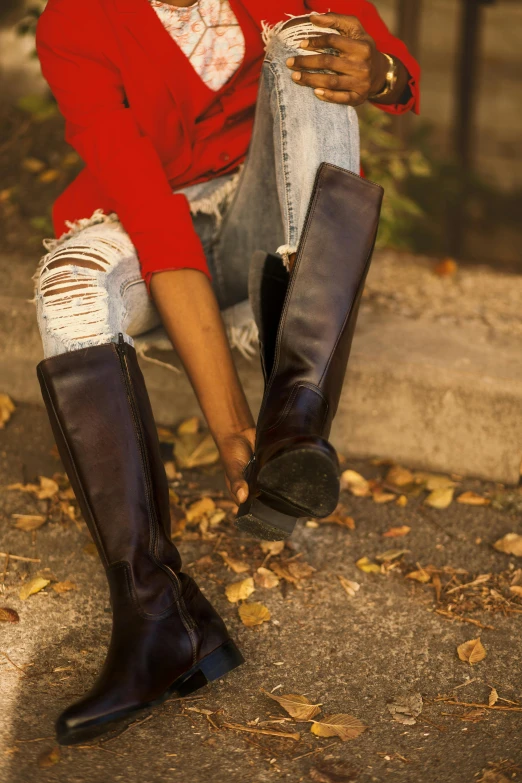 woman with leg boots in place of foot wear seated in concrete