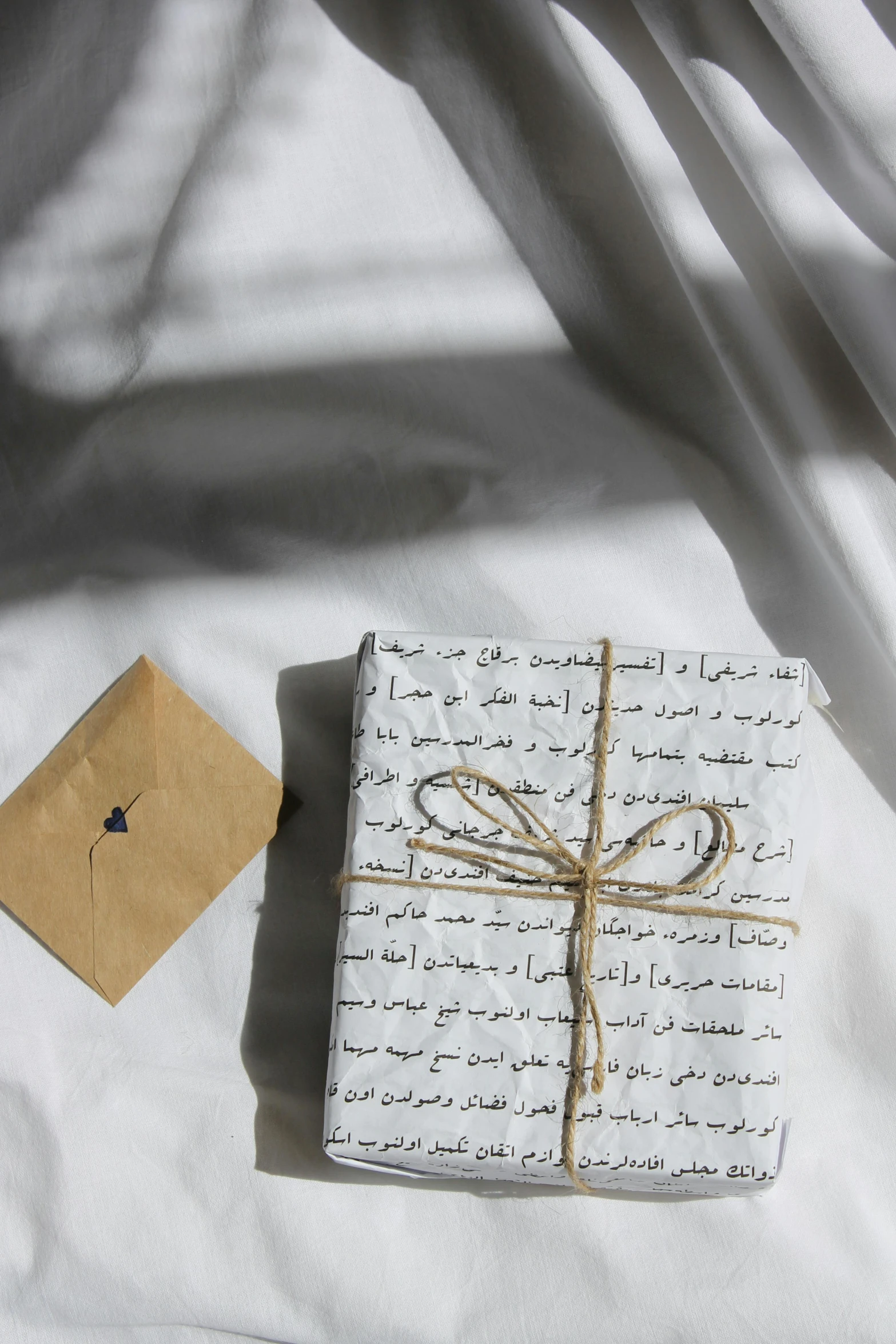 a wrapped gift and an envelope on a bed