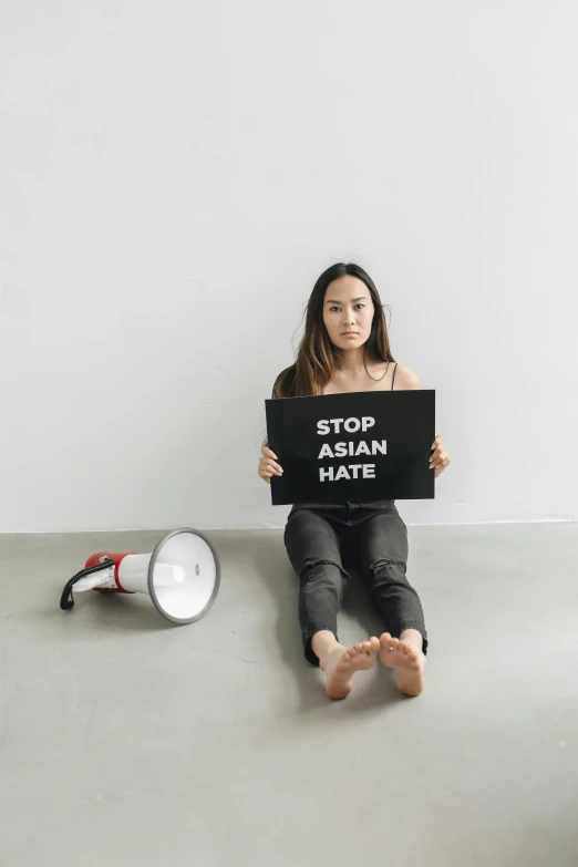 an asian woman holding up a sign against a white background