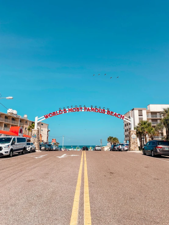 a view from a beach road with parked cars on it