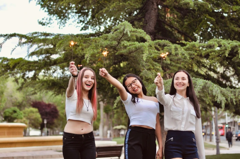 three girls laughing and holding up their fireworks