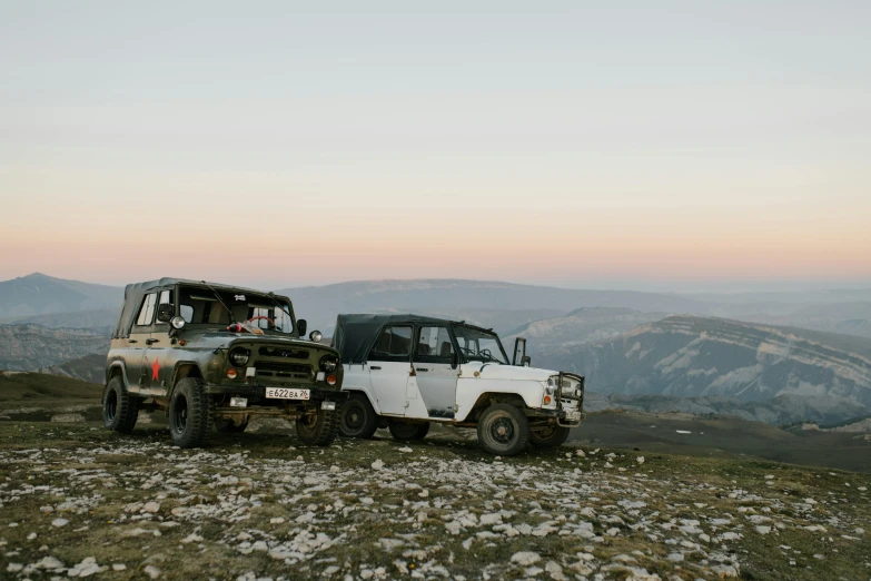 a truck towing a jeep on the side of a mountain