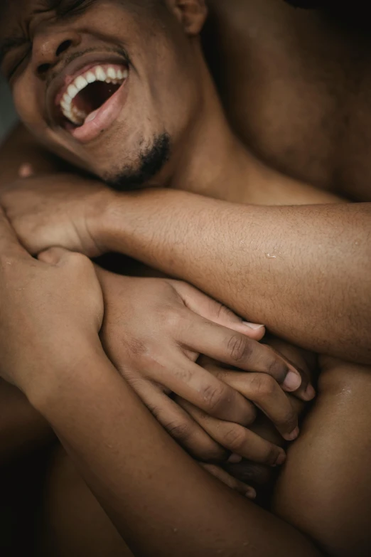 man holding his hands around another person, both with their arms wrapped around him