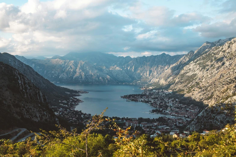 a scenic area with a lake in the center and mountains in the background