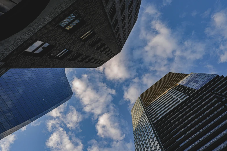 two tall buildings and one smaller building in front of the sky