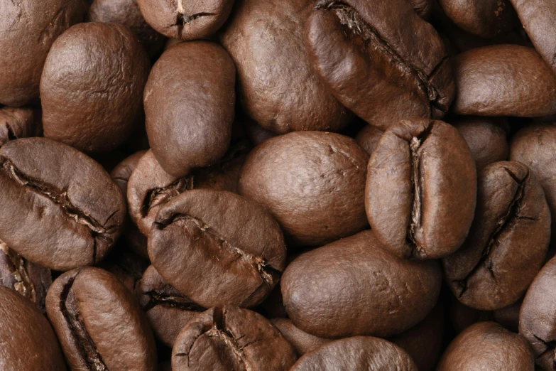 a pile of coffee beans with brown spots on them