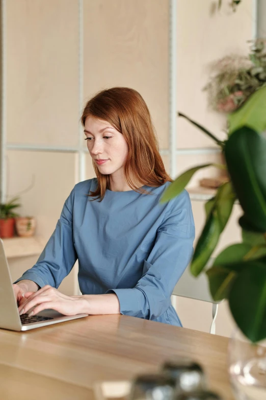 a woman uses her laptop at the desk