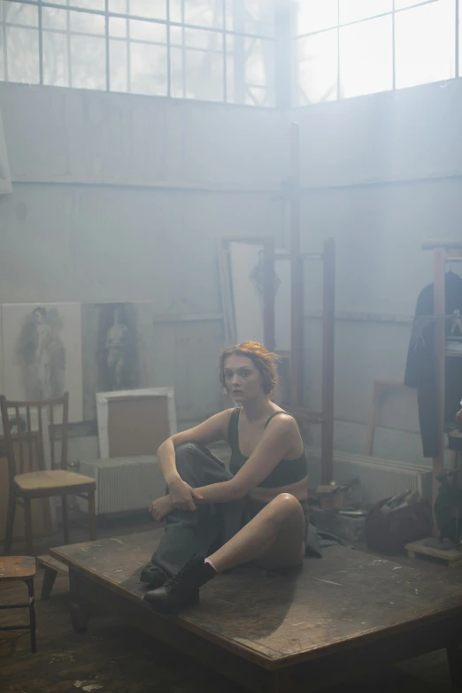 a young woman sits in an unfinished room