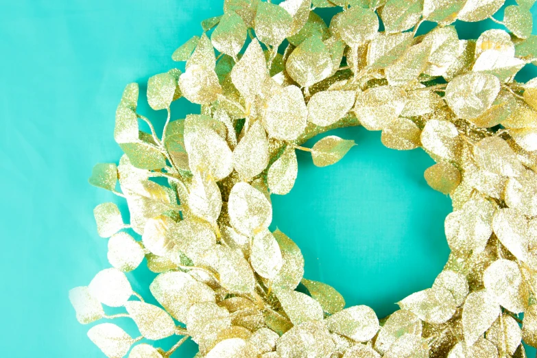 a gold leaf wreath placed on a blue backdrop