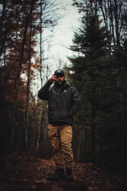 the man wearing a hat is standing in the woods