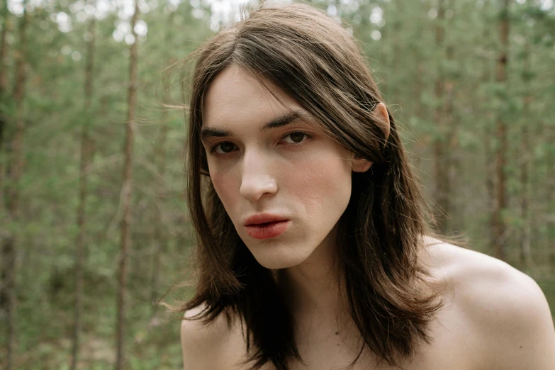 an image of a woman in the woods looking straight ahead