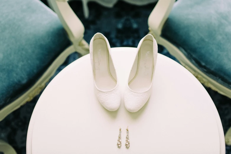 a pair of white high heels sitting on a table