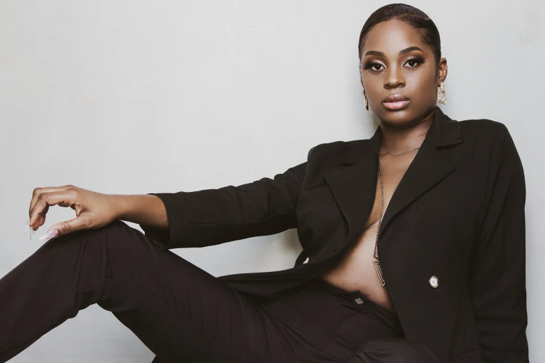 a black woman with a very big  is sitting on the floor