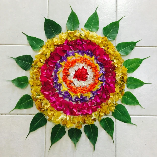 a circular flower decoration made of colored petals on white tiles