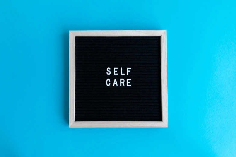 someone wrote self care on a card in the shape of a square