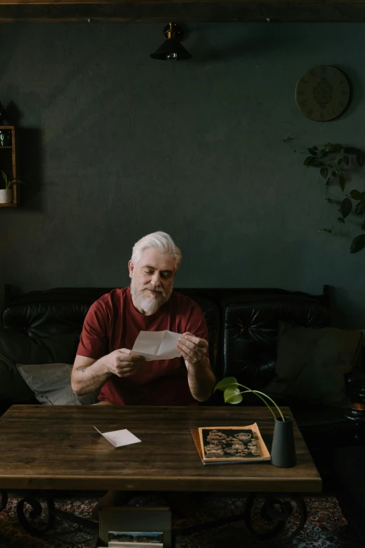 an older man is reading at a table