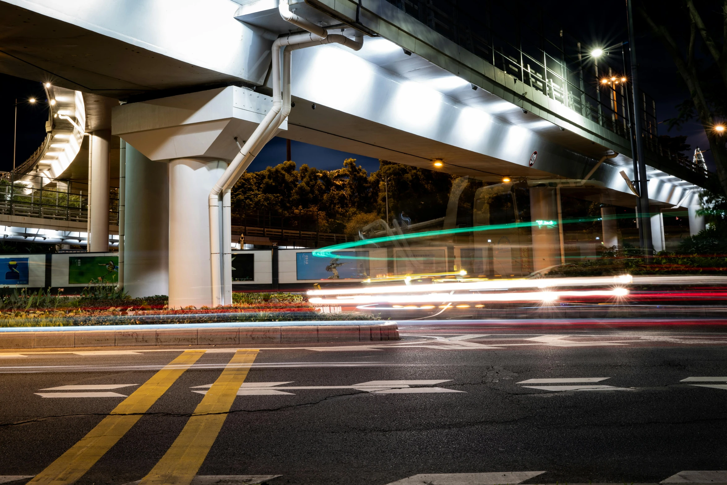 an overpass going over an empty road at night