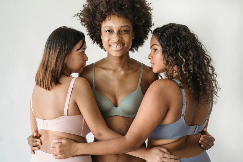 three women standing in underwear with their arms around each other