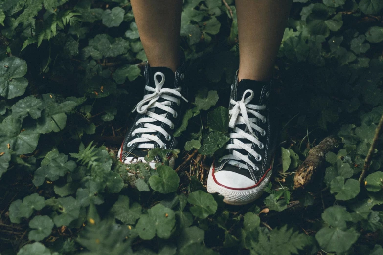 a person's legs wearing black and white sneakers
