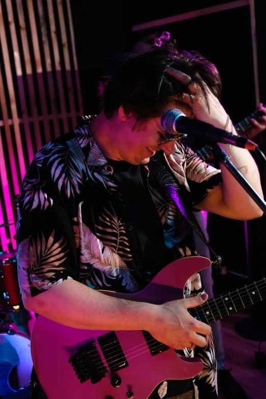 a man singing into a microphone while playing an electric guitar