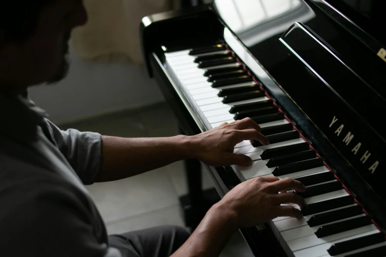 the man is sitting at the piano playing the song