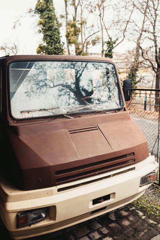 a van parked in front of a fence in the yard