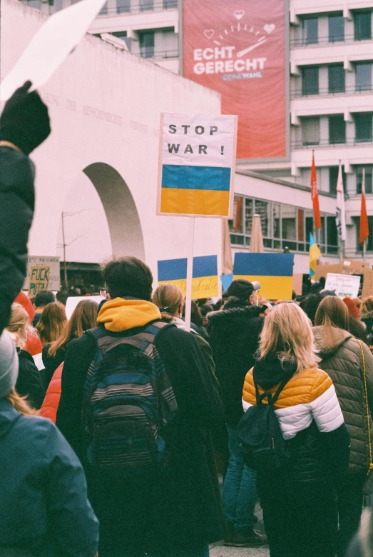 large group of people standing together with posters in the background