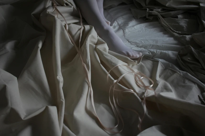 the white fabric is being made by a person laying in bed