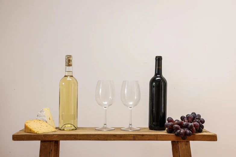 bottles and glasses sit next to wine and cheese