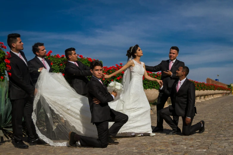 the bride and groom stand beside their groom as he lays in front of the bride and grooms