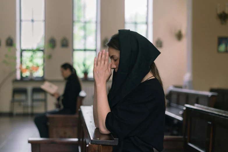 a person is kneeling down and praying in a church