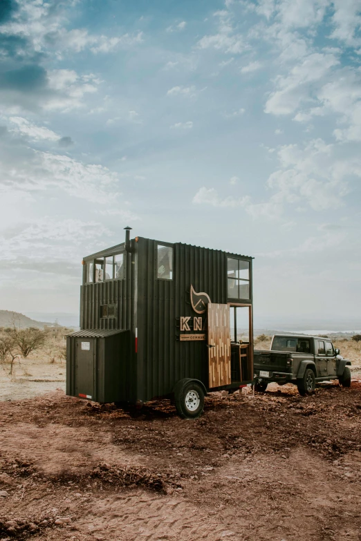 a truck parked on dirt next to a tall house